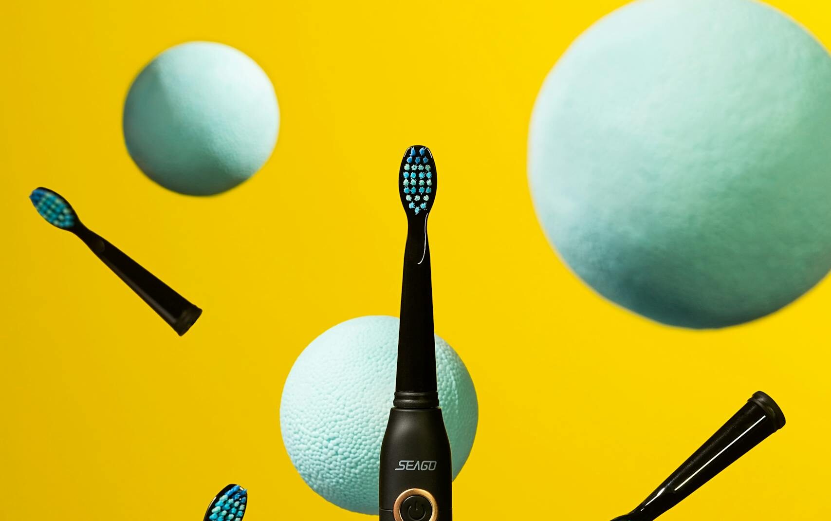 Dynamic studio shot of an electric toothbrush with colorful floating elements.