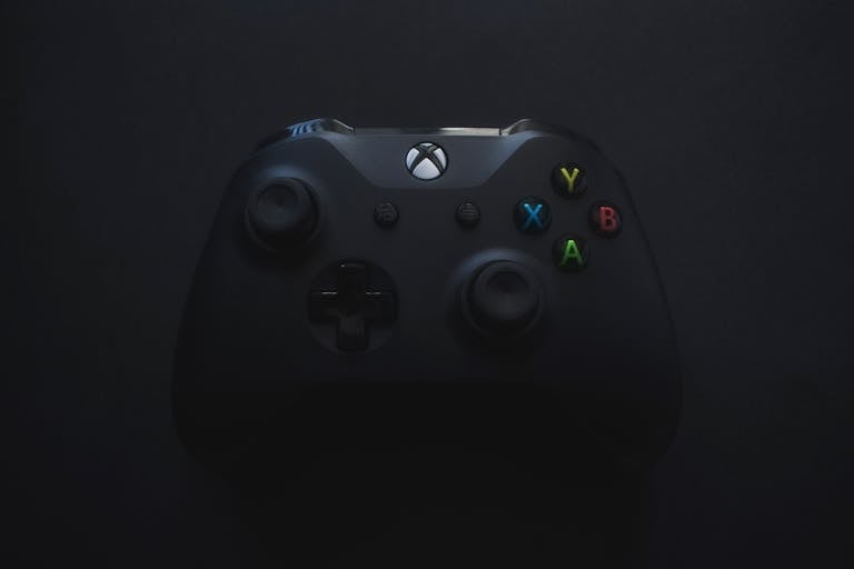 Xbox controller illuminated against a dark background, perfect for gaming themes.